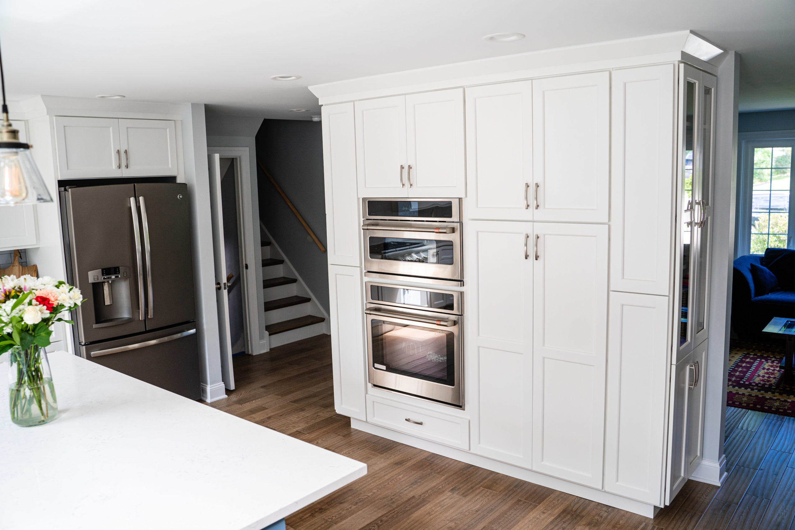 White cabinets in the middle of an open kitchen.