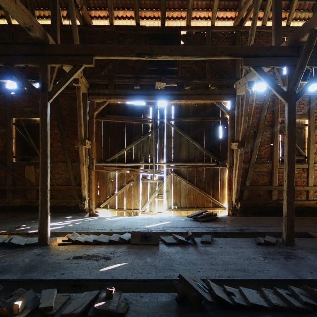 Dark, deserted building with lumber scattered about.