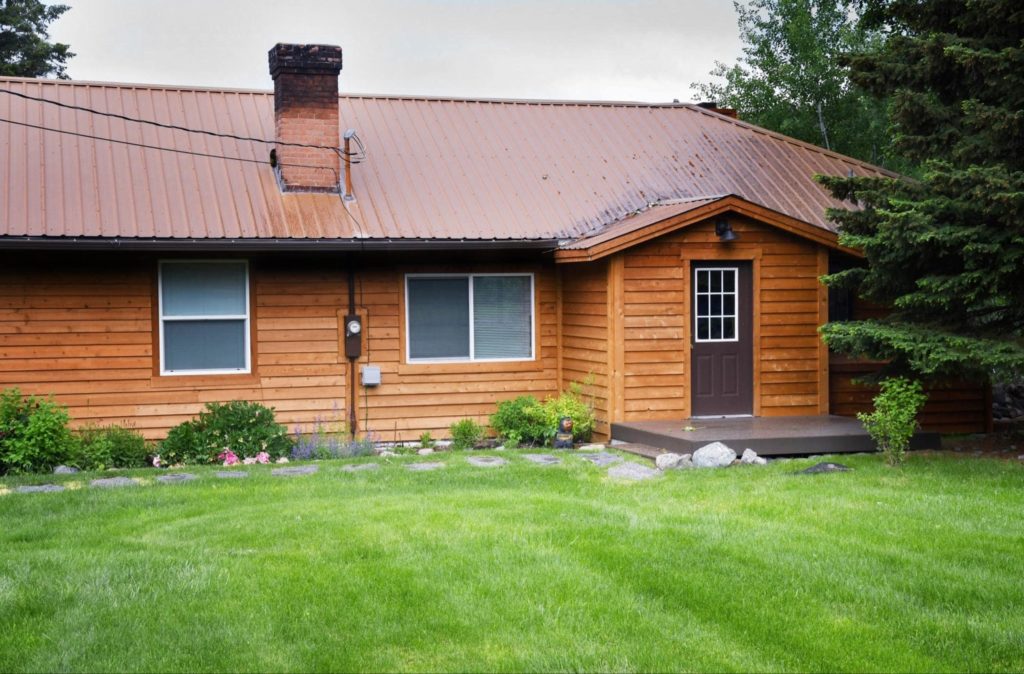 A picture of a home with wood siding after rain.