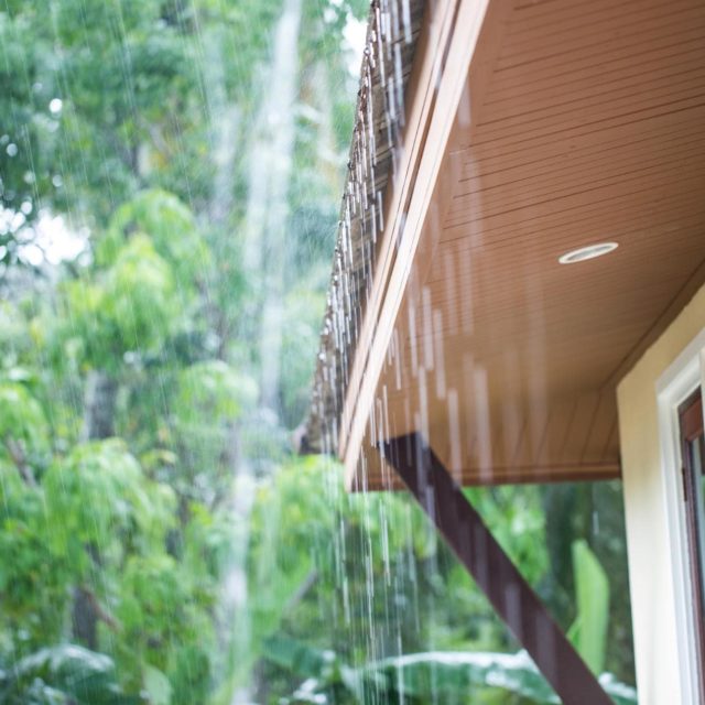 Side of a roof with rain running off of it.