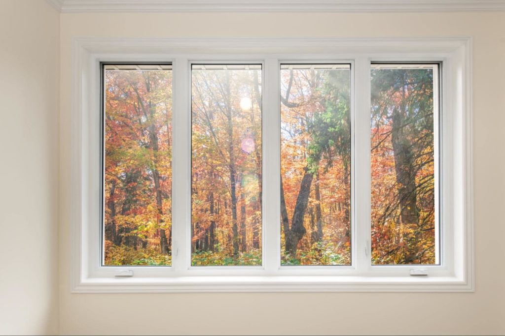 An inside shot of casement windows showcasing the fall foliage outside.