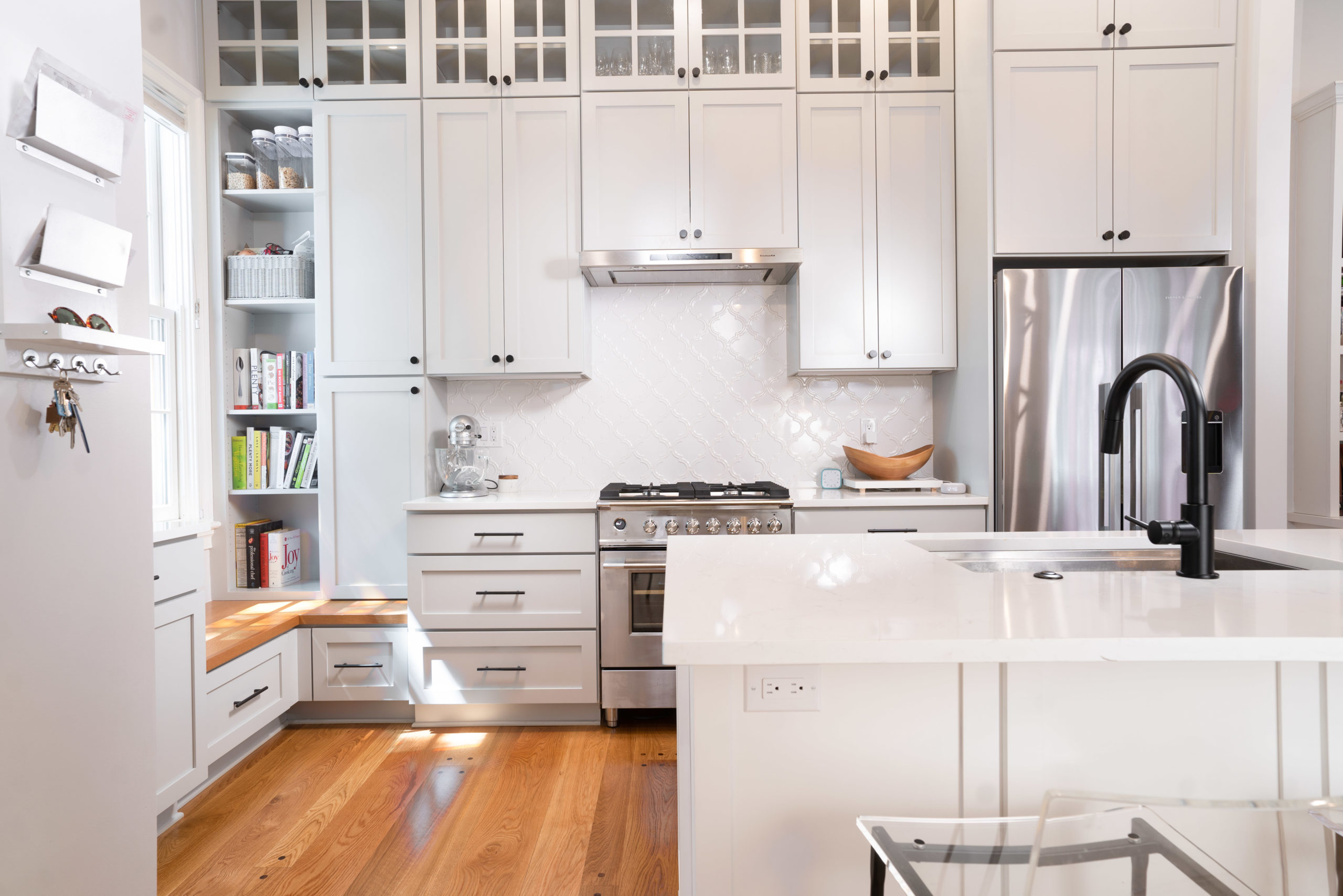 A white, recently-remodeled kitchen with island.