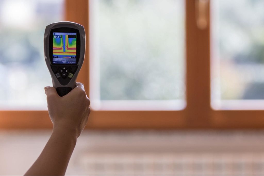 A handheld device measuring how to choose energy efficient windows.