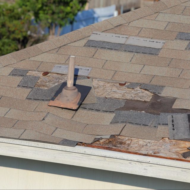 A roof with cracked and missing shingles.