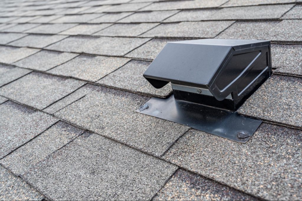 An image of a black metal roof vent on a roof.