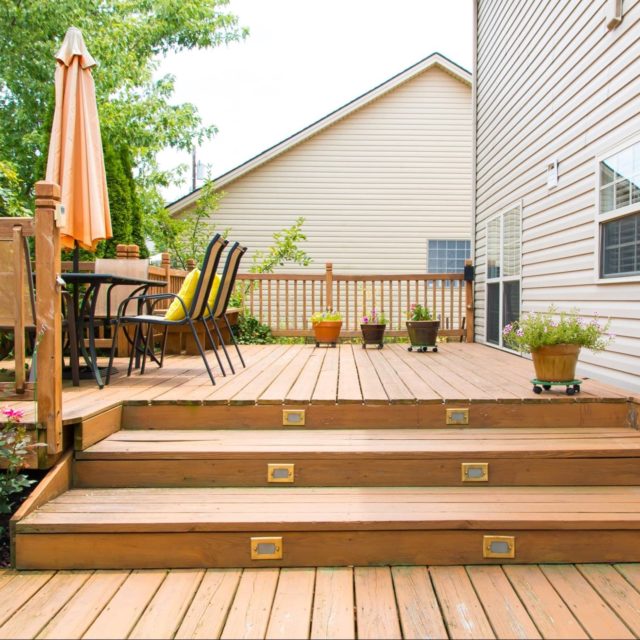 Wooden deck with patio furniture and potted plants.