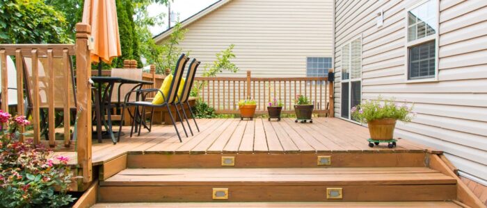 Wooden deck with patio furniture and potted plants.