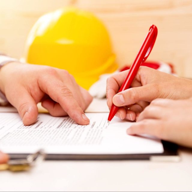 Person signing a contract after meeting with contractor.