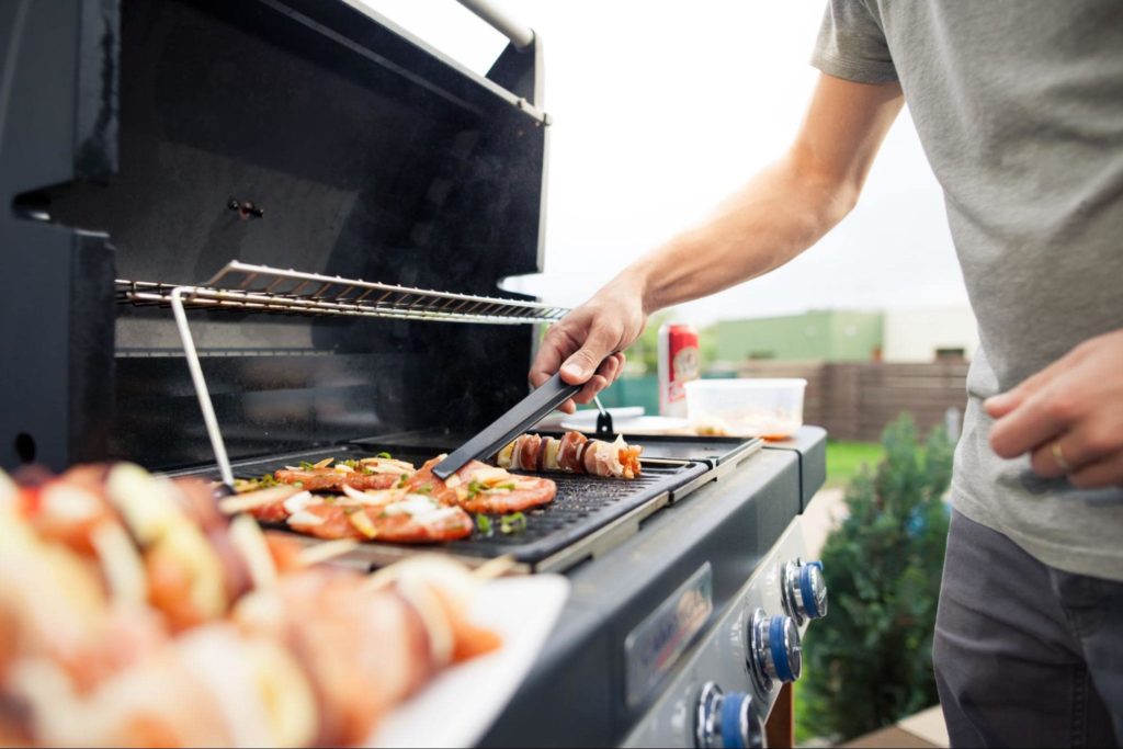 A picture of a man grilling outdoors.