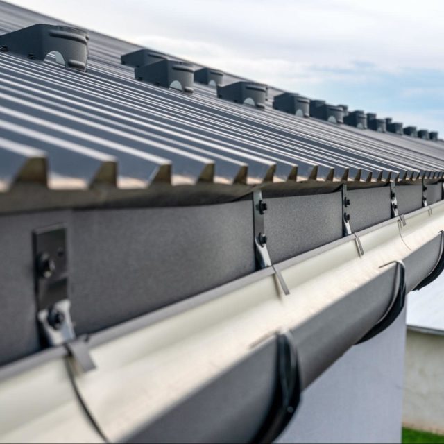 A close-up photo of matte black gutters on a home.