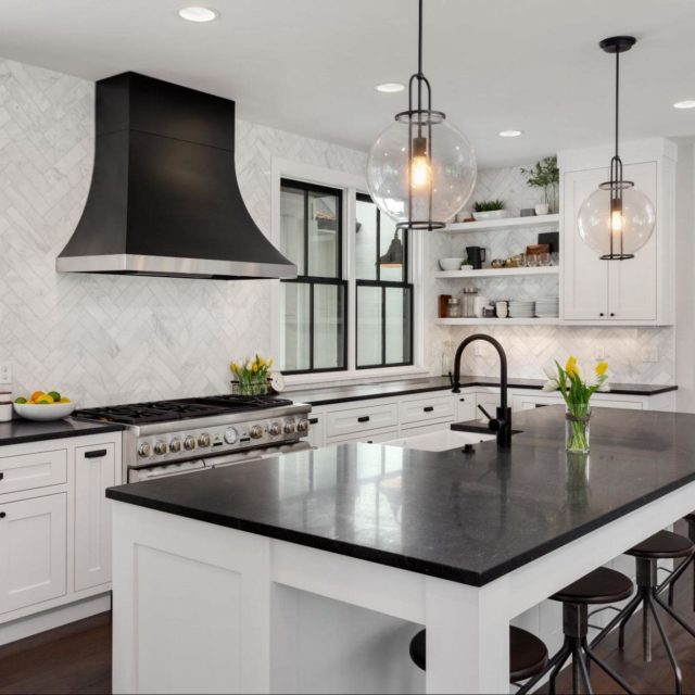 A modern kitchen with white cabinets and black accents.