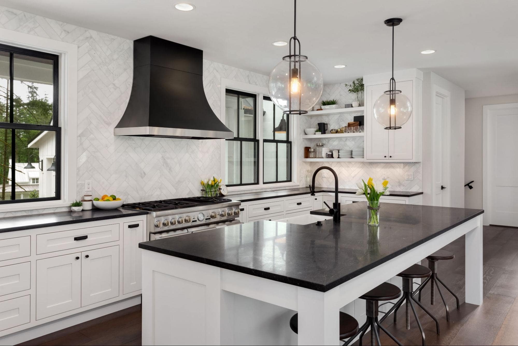 A modern kitchen with white cabinets and black accents.