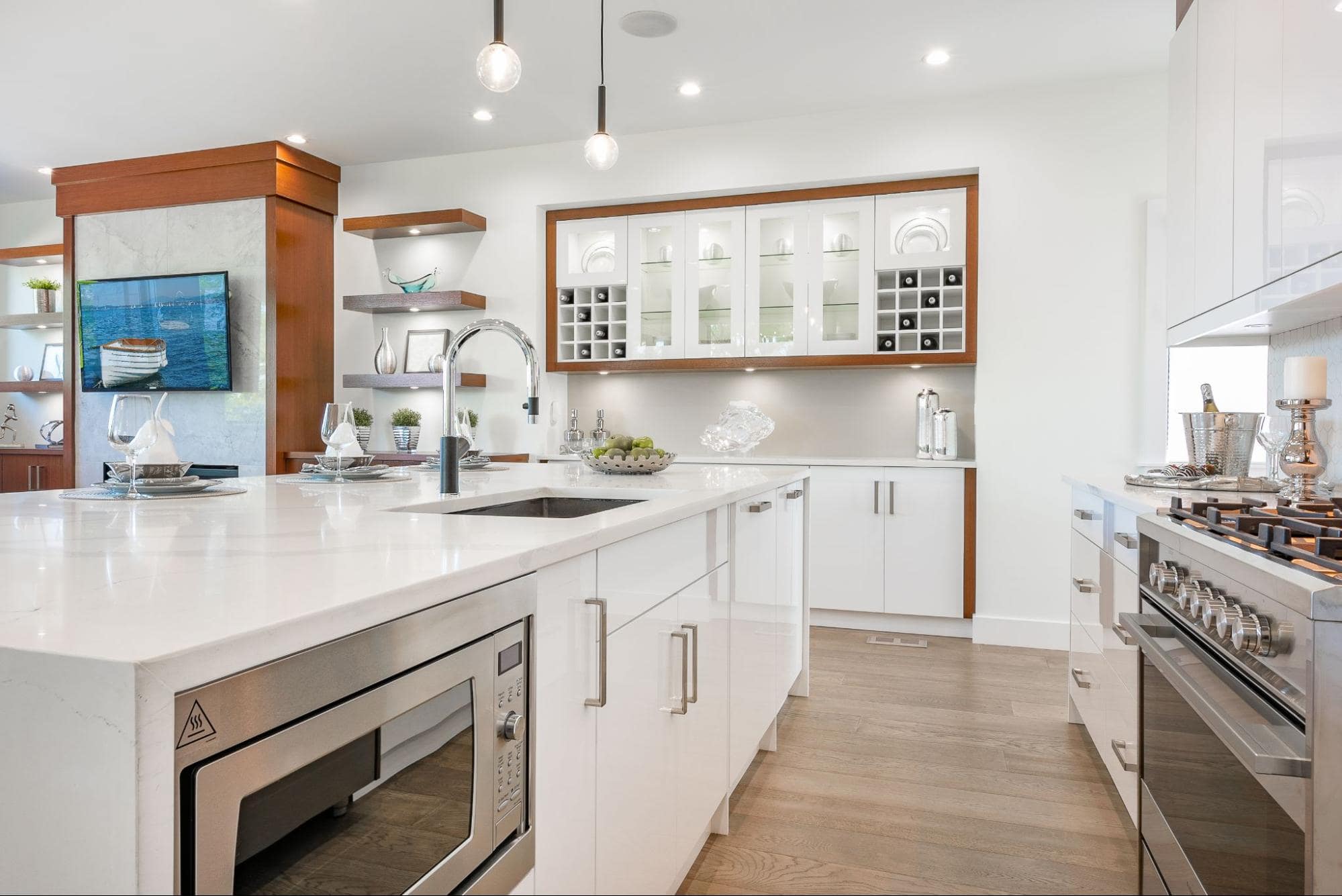 A modern kitchen with white cabinets and a hardwood floor.