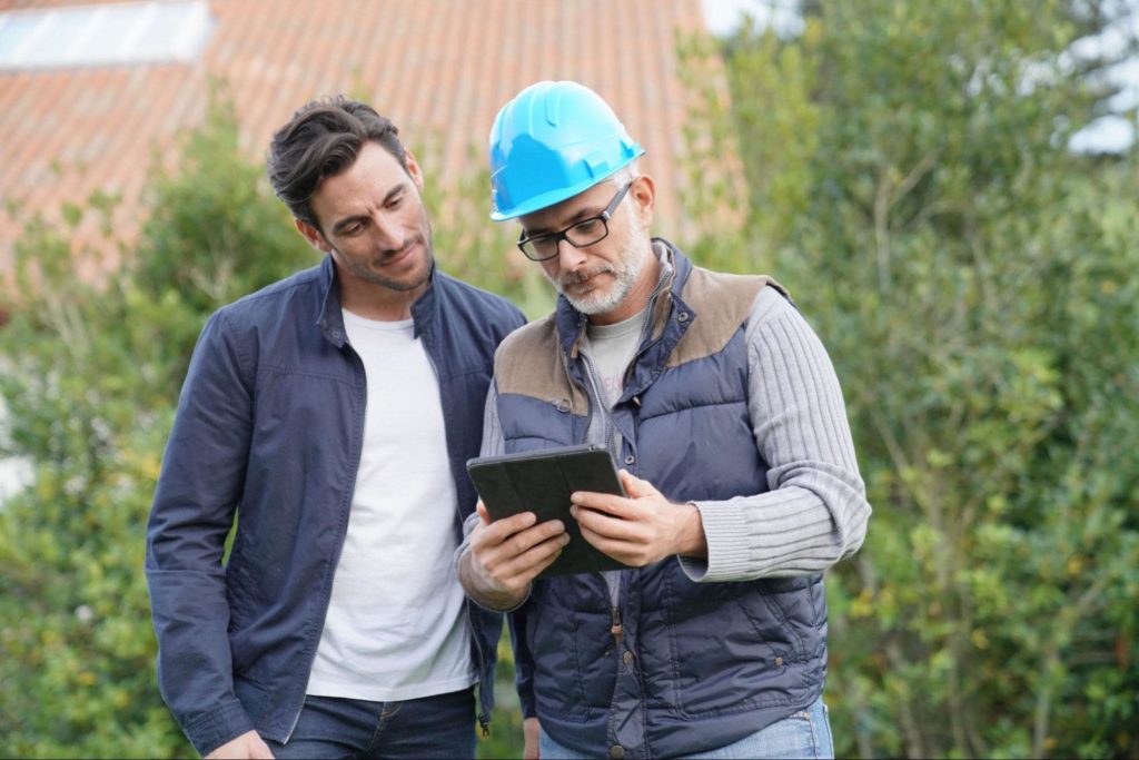 A contractor and a homeowner reviewing home details together.