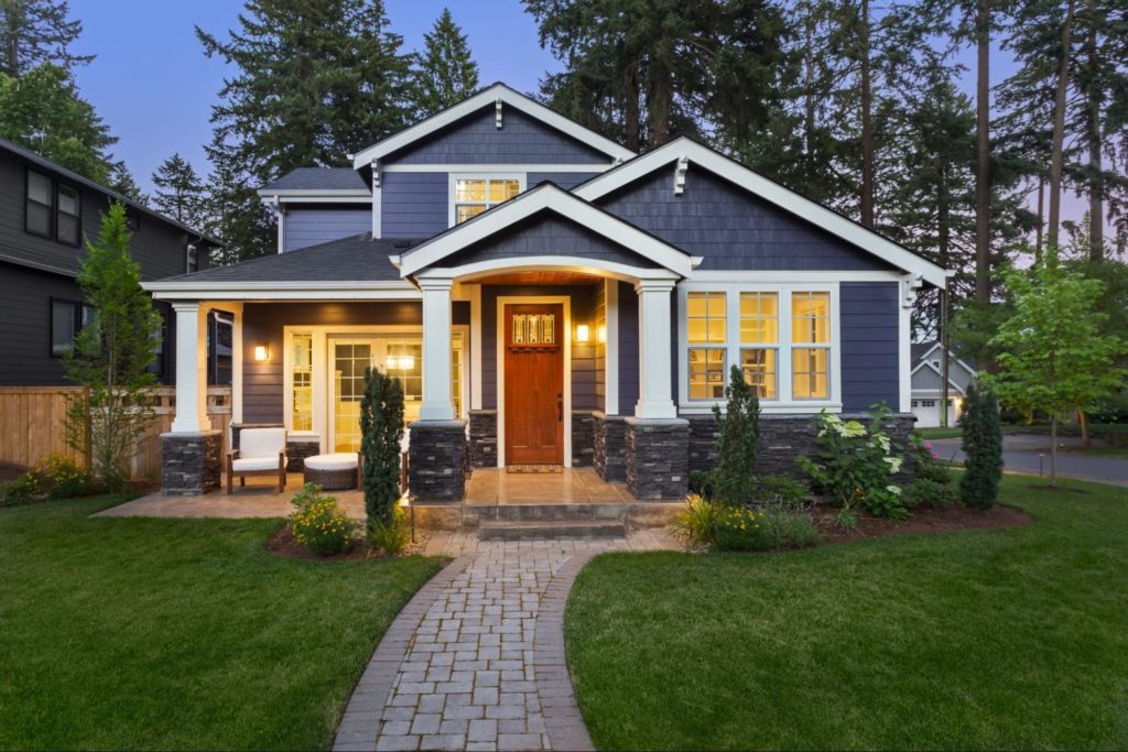 A beautiful home with blue siding, white trim, and white columns in the front.