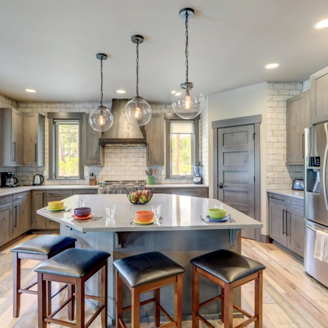 A kitchen design idea with stainless steel appliances and gray cabinets, with a granite-topped island.