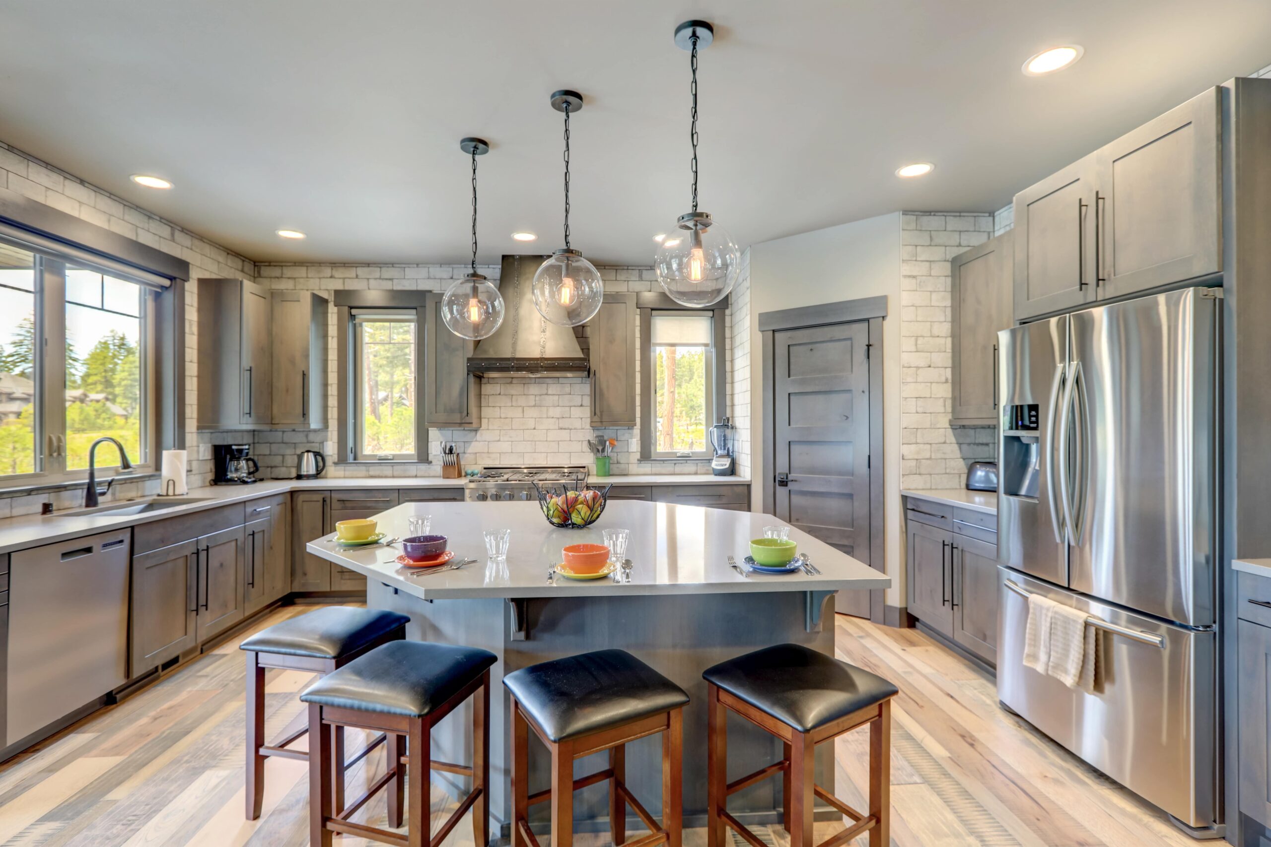 A kitchen design idea with stainless steel appliances and gray cabinets, with a granite-topped island.