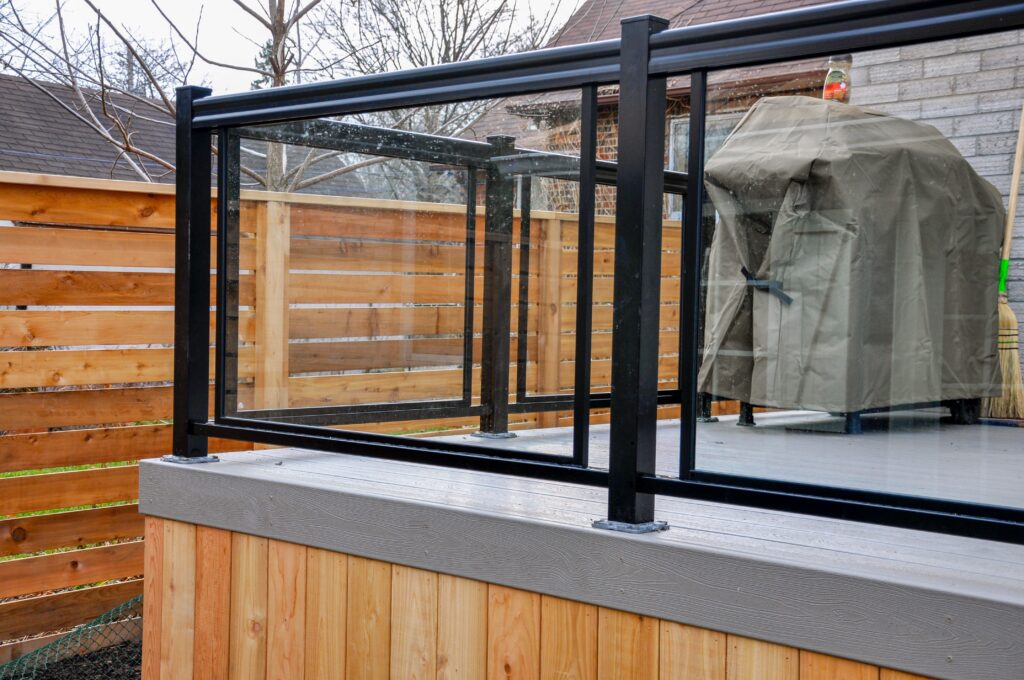 A close-up shot of a glass railing on a wooden deck.