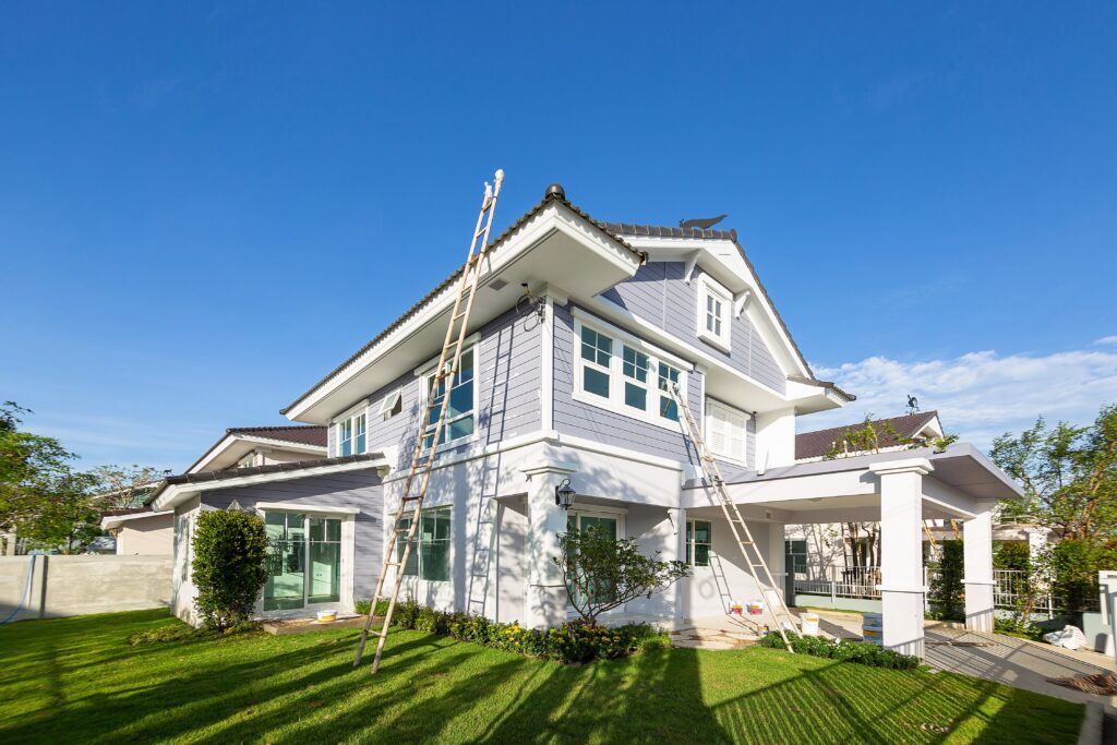 The outside of a home being remodeled with the ladders set against the siding.