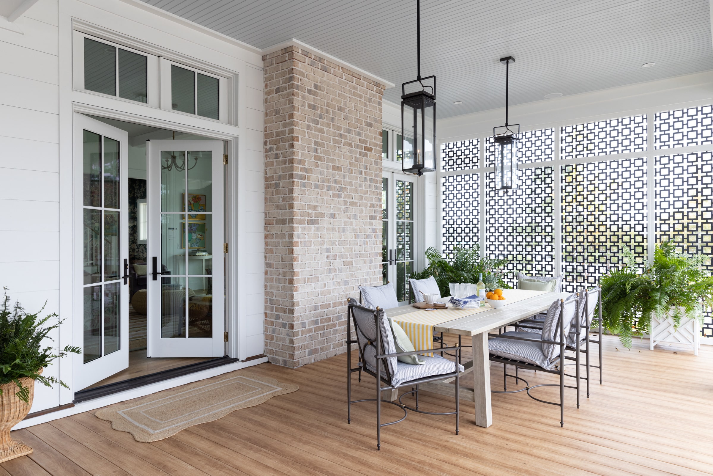 outdoor porch with dining table and white Marvin Exterior doors slightly opened