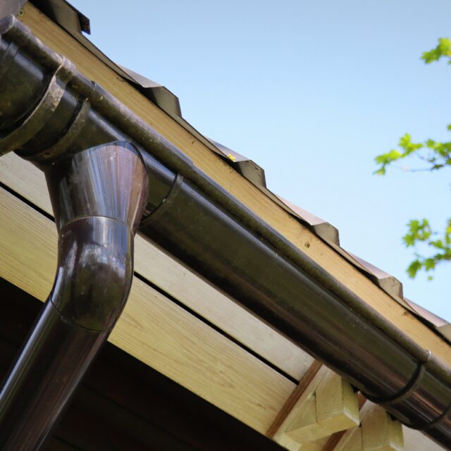 A close up of a gutter and downspout on a roof